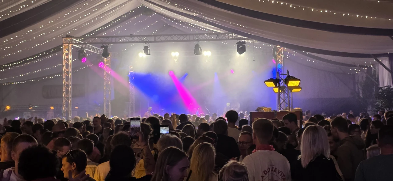 Volles Partyzelt mit Bühne und Lichtshow